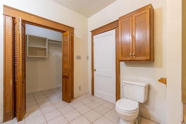 bathroom with toilet, tile patterned flooring, and baseboards