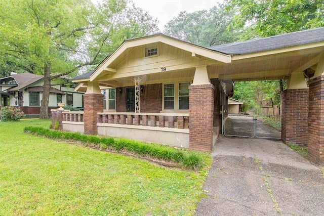 craftsman-style house with brick siding, aphalt driveway, an attached carport, a gate, and a front yard