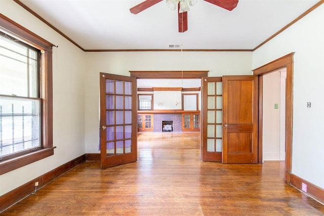 unfurnished room with ornamental molding, french doors, baseboards, and wood finished floors