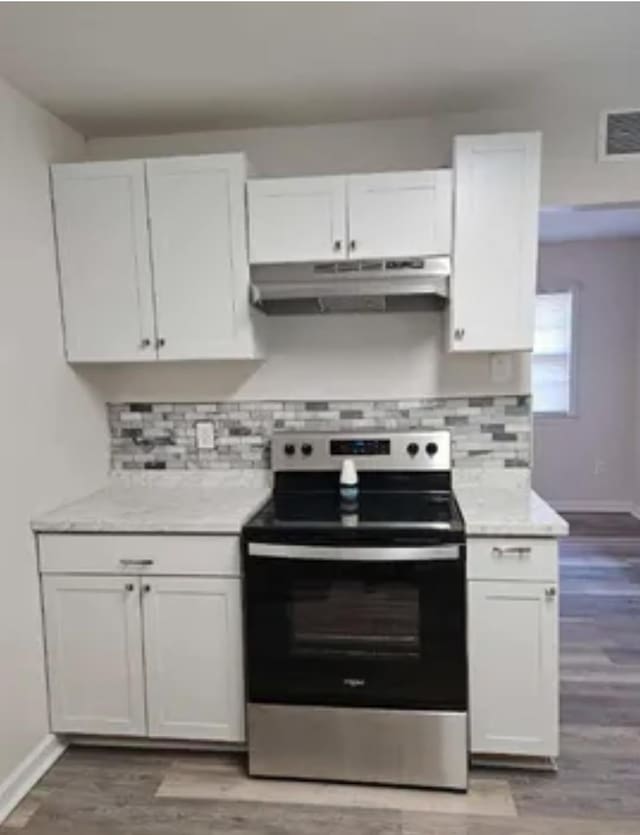 kitchen with light countertops, white cabinetry, stainless steel range with electric stovetop, and under cabinet range hood