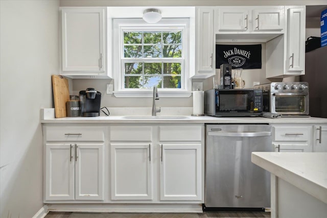 kitchen featuring white cabinets, a sink, black microwave, dishwasher, and baseboards