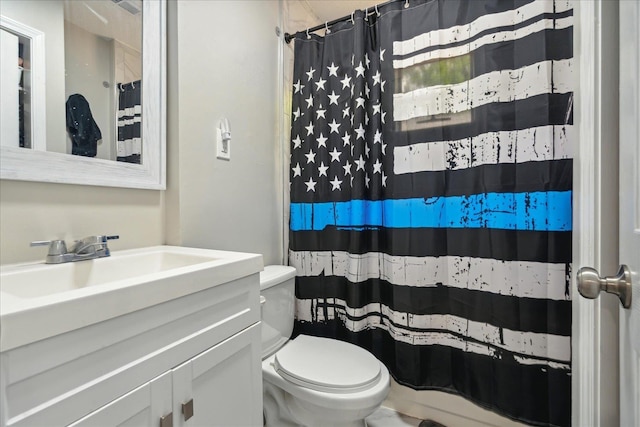 full bath with curtained shower, vanity, and toilet