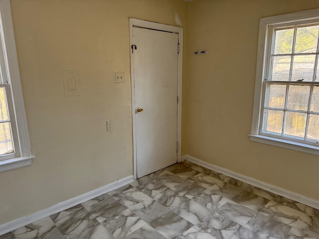 empty room with marble finish floor and baseboards