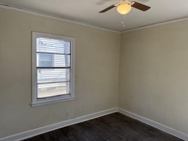 unfurnished room featuring a healthy amount of sunlight, dark wood-style floors, baseboards, and crown molding