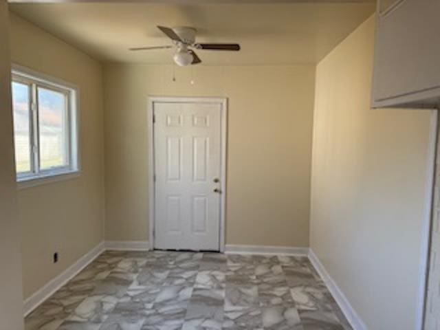 unfurnished room featuring ceiling fan and baseboards