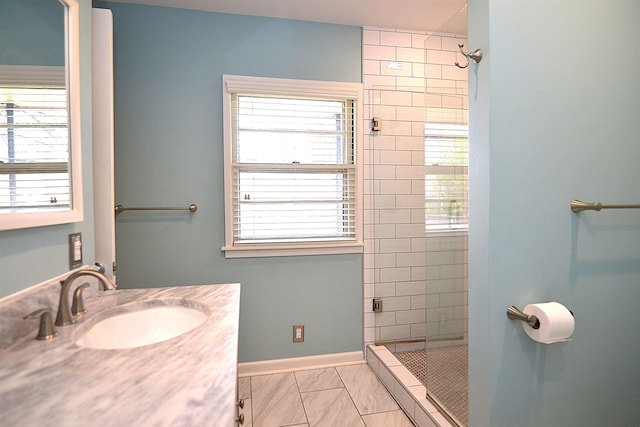 full bath featuring baseboards, a tile shower, and a wealth of natural light