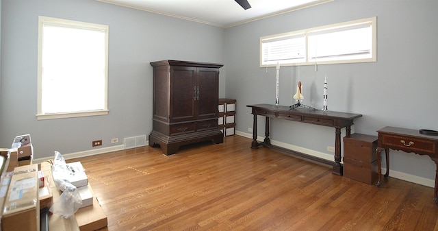 misc room featuring visible vents, ornamental molding, a wealth of natural light, and wood finished floors