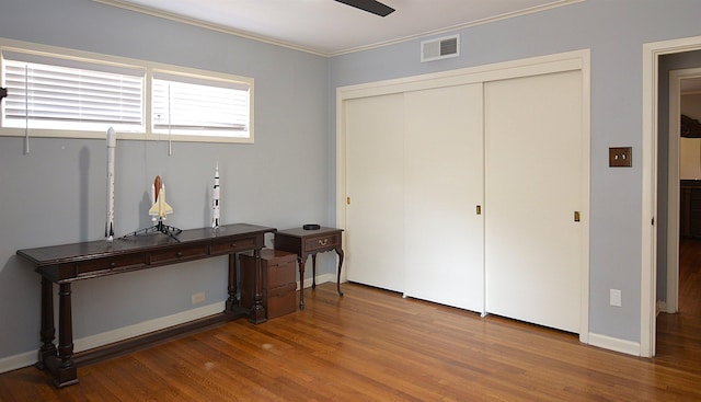 home office with baseboards, visible vents, ceiling fan, wood finished floors, and crown molding