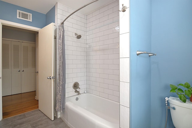 full bathroom featuring shower / bath combo, visible vents, toilet, wood finished floors, and a closet