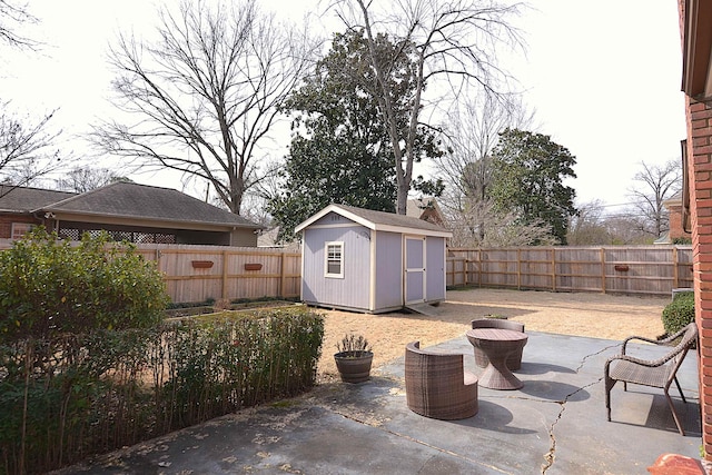 view of patio / terrace with a fenced backyard, an outdoor structure, and a shed