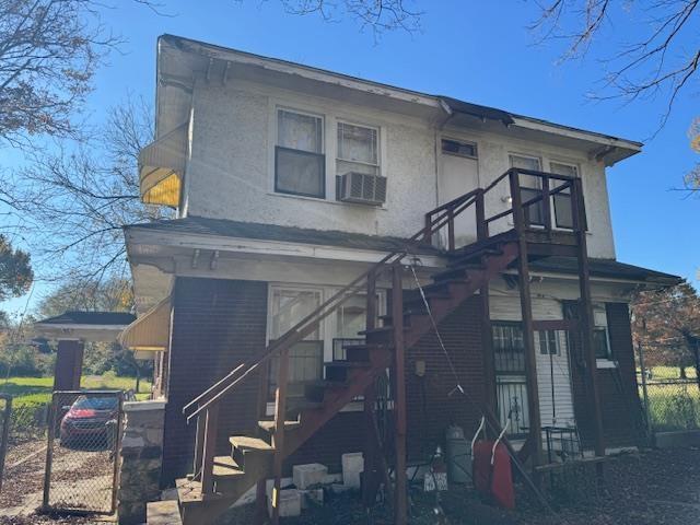 view of front facade with stairs, cooling unit, and fence