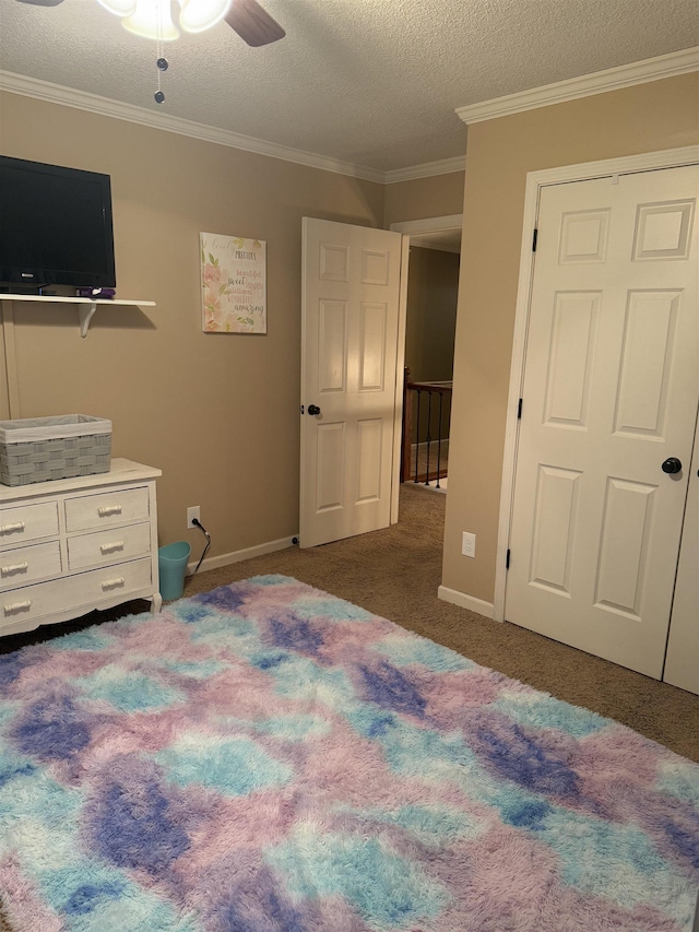 bedroom featuring ornamental molding, dark carpet, a textured ceiling, and baseboards