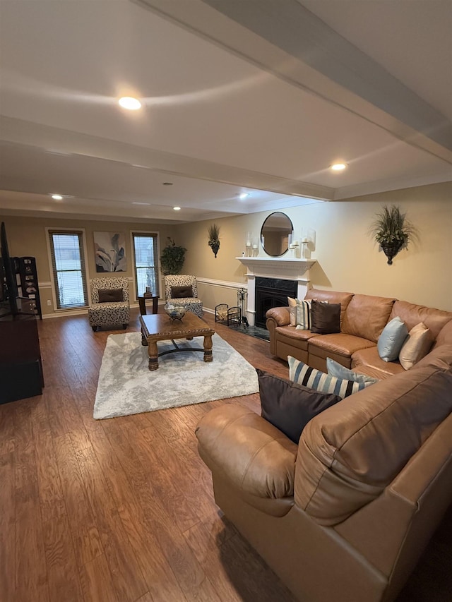 living room featuring beam ceiling, recessed lighting, a fireplace with flush hearth, wood finished floors, and baseboards