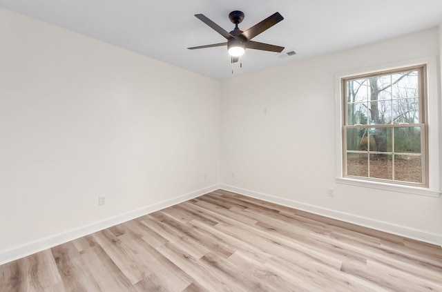 spare room featuring light wood-style flooring, visible vents, baseboards, and a ceiling fan