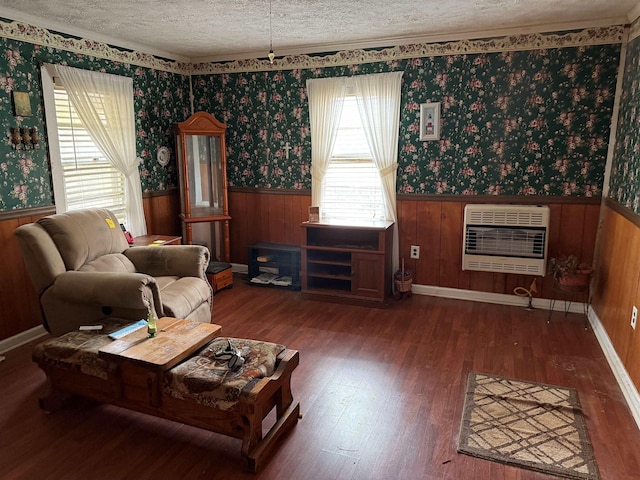 living room with heating unit, dark wood-style floors, a textured ceiling, and wainscoting