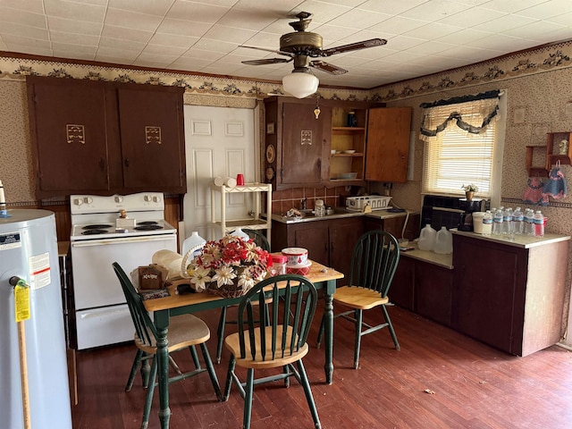 kitchen featuring wallpapered walls, a ceiling fan, electric stove, dark wood-style flooring, and water heater