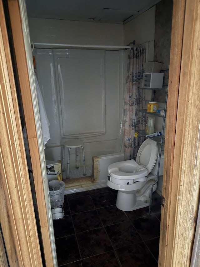 bathroom with toilet, shower / tub combo, and tile patterned flooring