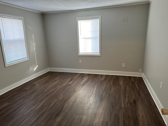 empty room featuring dark wood finished floors, a textured ceiling, and baseboards