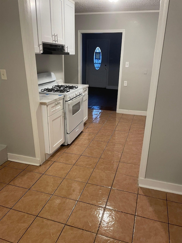 kitchen featuring light tile patterned floors, under cabinet range hood, white cabinets, white range with gas cooktop, and light countertops