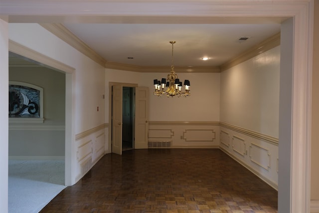 unfurnished dining area featuring a decorative wall, a notable chandelier, visible vents, wainscoting, and crown molding