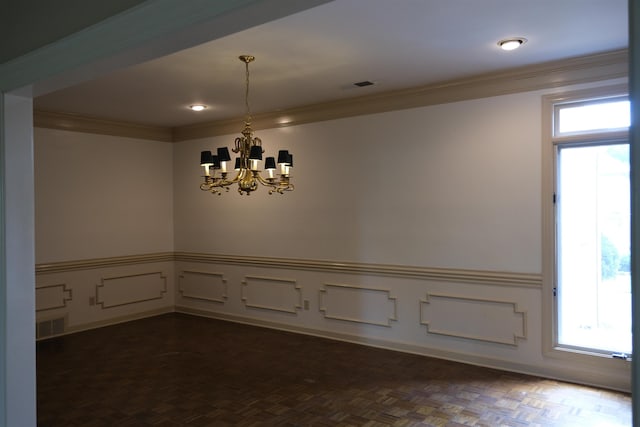 unfurnished dining area featuring a chandelier, wainscoting, visible vents, and crown molding