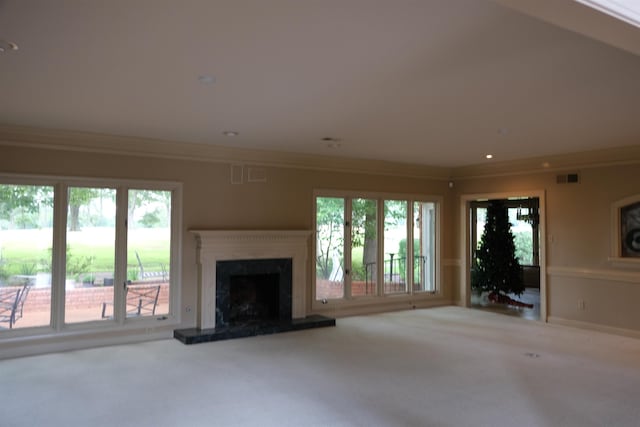 unfurnished living room featuring a high end fireplace, carpet, visible vents, and crown molding