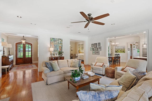 living room featuring recessed lighting, baseboards, ornamental molding, french doors, and light wood finished floors