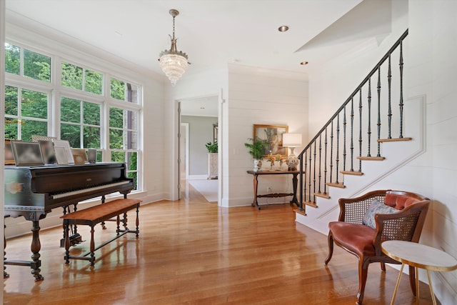 foyer entrance with wood finished floors, stairs, crown molding, a chandelier, and recessed lighting