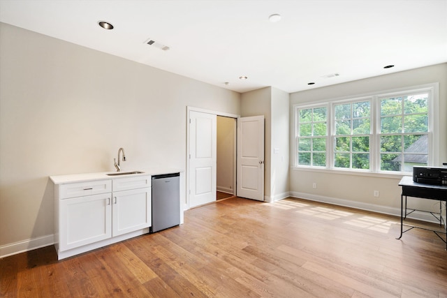 interior space featuring visible vents, white cabinets, dishwasher, light countertops, and a sink