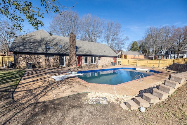 view of pool with a fenced in pool, a patio, fence, a diving board, and central AC