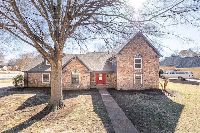 view of front of house with roof with shingles and brick siding