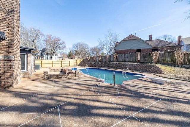 view of swimming pool with a patio, central AC unit, a fenced backyard, a diving board, and a fenced in pool