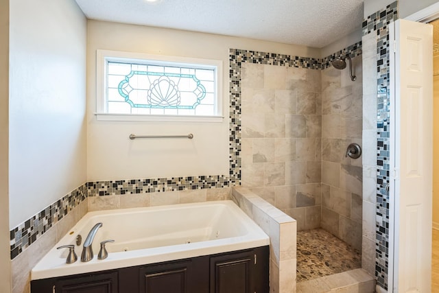 bathroom with tiled shower, a textured ceiling, and a whirlpool tub