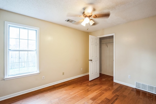 unfurnished bedroom featuring wood finished floors, visible vents, and baseboards