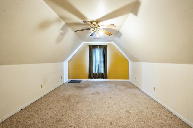 bonus room featuring lofted ceiling, carpet, baseboards, and a ceiling fan