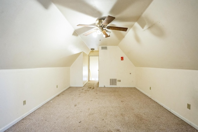 additional living space featuring baseboards, visible vents, a ceiling fan, carpet, and vaulted ceiling