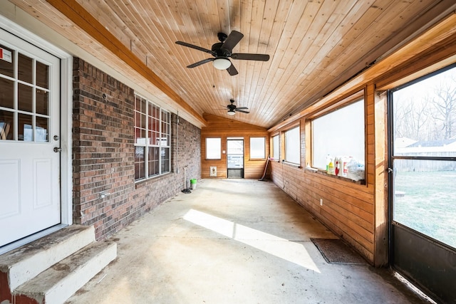 unfurnished sunroom featuring lofted ceiling, wood ceiling, and a ceiling fan