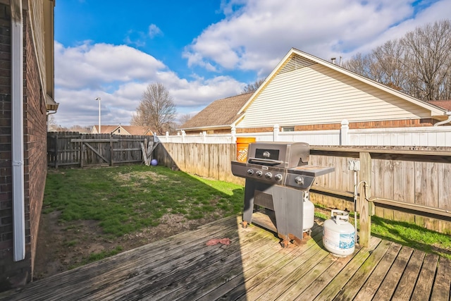 deck featuring a yard, grilling area, and a fenced backyard