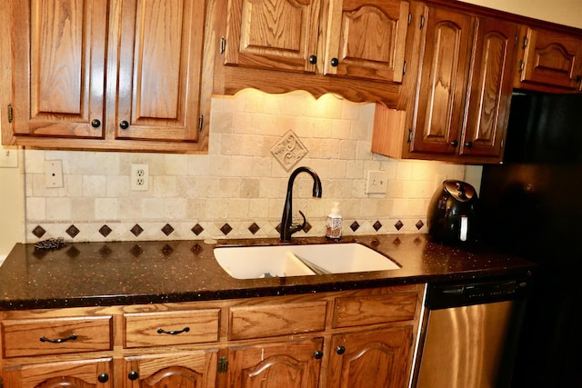 kitchen with a sink, decorative backsplash, dishwasher, and freestanding refrigerator