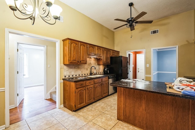 kitchen with visible vents, dark countertops, freestanding refrigerator, stainless steel dishwasher, and a sink