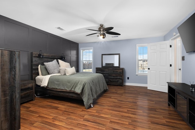 bedroom with dark wood-type flooring, visible vents, ceiling fan, and baseboards