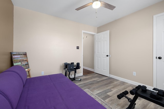 bedroom with ceiling fan, baseboards, and wood finished floors