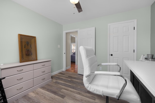 home office featuring dark wood finished floors, a ceiling fan, and baseboards