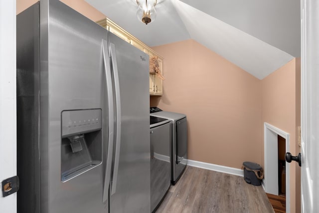 clothes washing area with light wood-style floors, cabinet space, independent washer and dryer, and baseboards