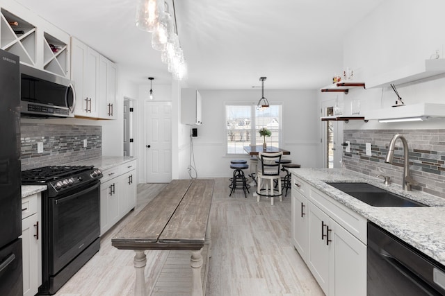 kitchen with open shelves, black appliances, and white cabinets