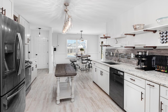 kitchen with a sink, white cabinets, stainless steel fridge with ice dispenser, dishwasher, and decorative light fixtures