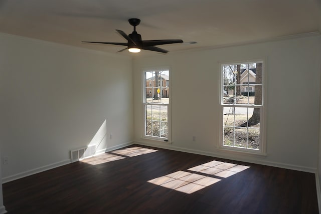 empty room featuring baseboards, visible vents, ceiling fan, ornamental molding, and wood finished floors