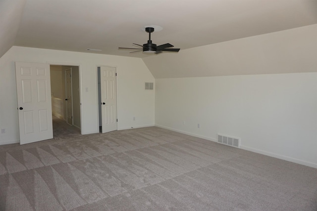 additional living space with lofted ceiling, visible vents, ceiling fan, and carpet flooring