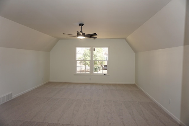 bonus room with vaulted ceiling, light colored carpet, visible vents, and baseboards