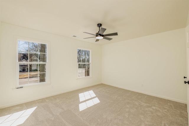 empty room with a ceiling fan, light colored carpet, and baseboards